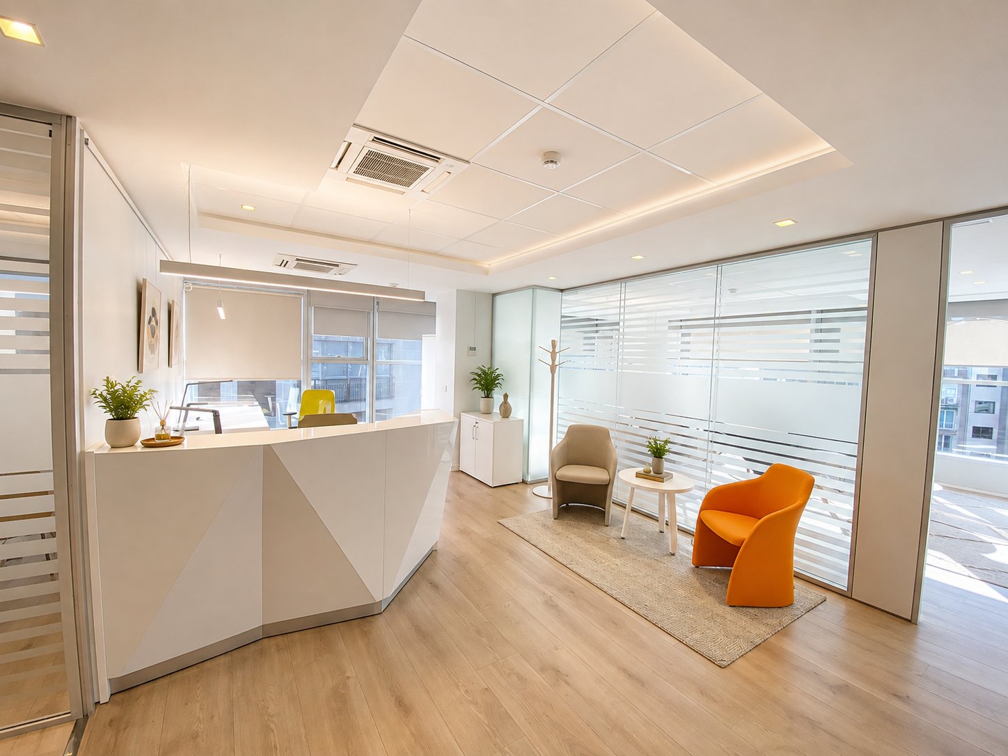 Another view of reception: orange and beige armchairs in front of the glazed wall with banded film, the façade windows behind